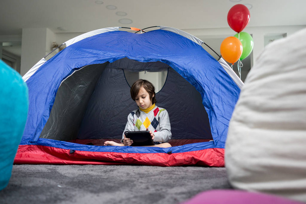 Kids having camping tent in living room for fun and adventure - Foto, immagini