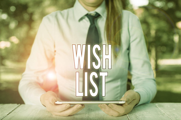 Writing note showing Wish List. Business photo showcasing List of desired but often realistically unobtainable items Female business person sitting by table and holding mobile phone. - Photo, Image