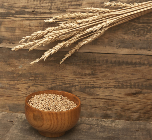 Orejas de trigo sobre una vieja tabla de madera
 - Foto, imagen