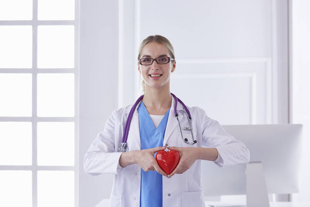 Médico com estetoscópio segurando coração, isolado no backgr branco
 - Foto, Imagem
