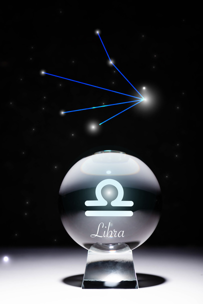 хрустальный шар с символом зодиака Весы, изолированный на черном с созвездием
 - Фото, изображение