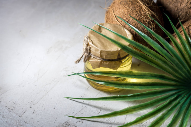 kókuszdió és egy üveg kókuszpálmaolaj. egészséges étel vegán aromaterápia koncepció - Fotó, kép