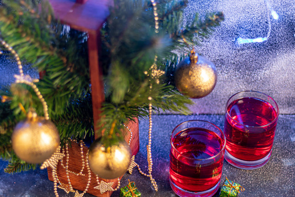Feestdrankje, rosé wijn op een donkere achtergrond. Nieuwjaarsrekwisieten, kunstsneeuw. Kopieerruimte.  - Foto, afbeelding