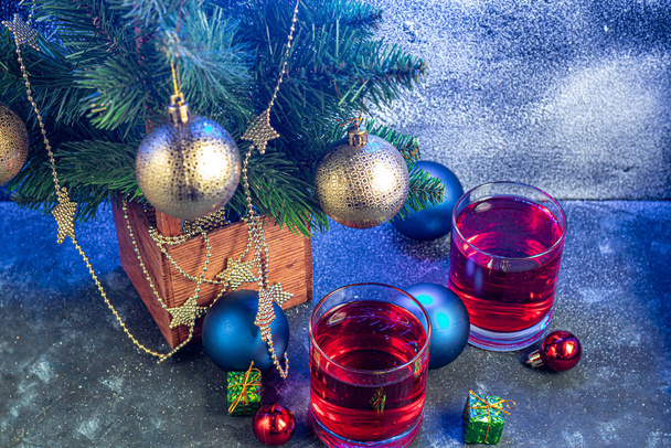 Feestdrankje, rosé wijn op een donkere achtergrond. Nieuwjaarsrekwisieten, kunstsneeuw. Kopieerruimte.  - Foto, afbeelding