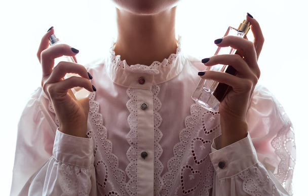 woman with perfume on light background  - Zdjęcie, obraz