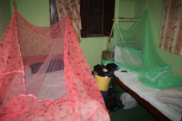 Kathmandu, Nepál - 7. dubna 2014: Velmi levný rozpočet hotel pro dva v Káthmándú s moskytiérou přes postel. Batoh u postele. - Fotografie, Obrázek