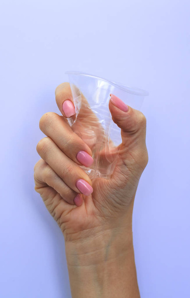 Женская рука держит пластиковое стекло. Пластиковые загрязнения
  - Фото, изображение
