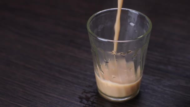 poured into a cup indian masala tea with milk and spices - Filmati, video