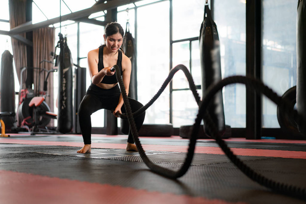 Beautiful Asian Woman with balck battle rope battle ropes exerci - 写真・画像
