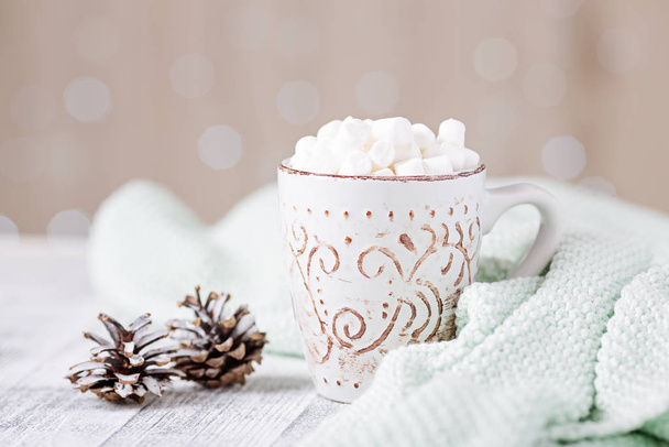 Mug with coffee and marshmallow, sweater, cinnamon. Cozy christmas composition. Hygge concept Soft focus - Zdjęcie, obraz