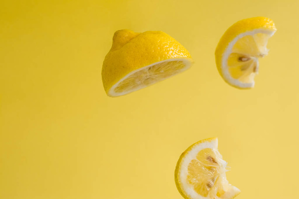Heldere achtergrond en citroenstukjes. Gezondheid. Vitamine C. Citrusvruchten. Tropische vruchten. - Foto, afbeelding