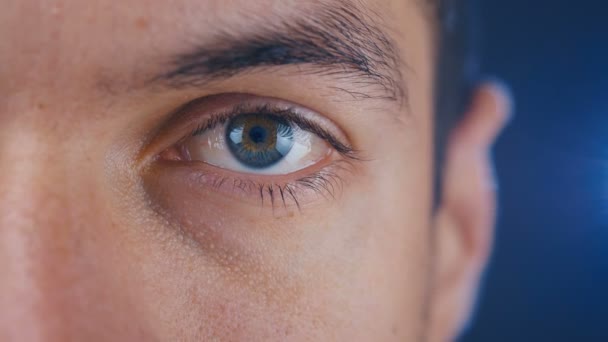 close-up macro blauw mans oog met blauwe achtergrond. Halfgezicht portret close-up. - Video