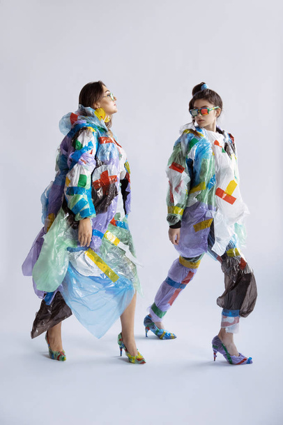 Women addicted of sales and clothes, wearing plastic, recycling concept - Photo, Image