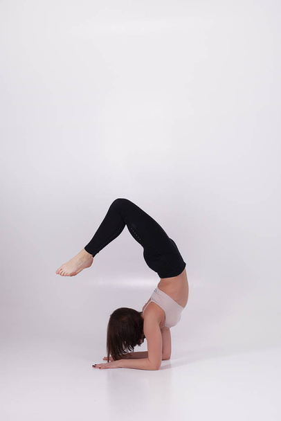 Young beautiful girl performs yoga exercises - 写真・画像