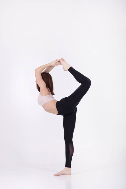 Young beautiful girl performs yoga exercises - 写真・画像