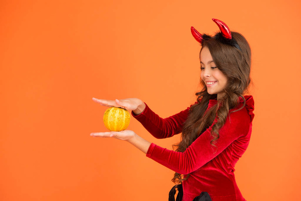 Have magic Halloween. Little demon child cast magic spell upon pumpkin. Pumpkin is magic vegetable. Charm or magic. Incantation or bewitchery. Enchantment, copy space - Fotografie, Obrázek
