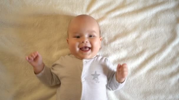 Sevimli bebek gülümsüyor ve kameraya bakıyor. Bir bebeğin portresi. Yakından, 4k. - Video, Çekim