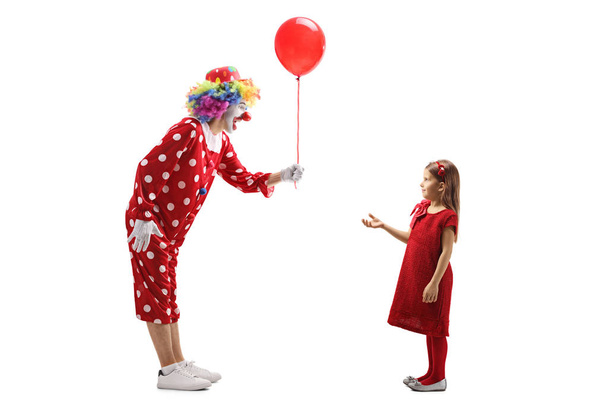Clown giving a red balloon to a little girl - Foto, Bild