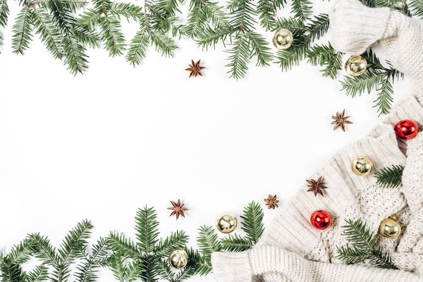 Kerst- of wintercompositie. Handgemaakte geschenkdozen versierd met ambachtelijk papier, boomtakken, trui op witte achtergrond. Vlakke lay, bovenaanzicht, kopieerruimte - Foto, afbeelding