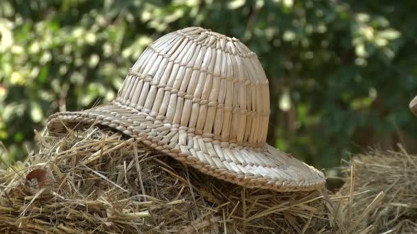 Stary słomkowy kapelusz leżący w muzeum etnograficznym jako eksponat odzieży domowej - Materiał filmowy, wideo