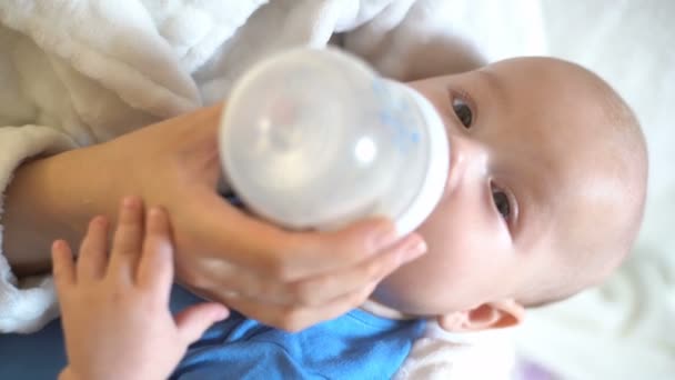 Lähikuva pullosta syövästä lapsesta, 4K. Äiti ruokkii vauvan pullosta, jossa on tutti. Vauvan lähikuva
. - Materiaali, video