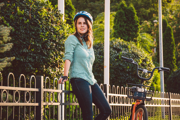 attraktive freundliche junge Frau mit ihrem Fahrrad. Porträt einer jungen Frau auf der Straße mit dem Fahrrad. ökologischer Fahrradtransport. Studentin kam mit Leihrädern zum Studium an die Universität - Foto, Bild