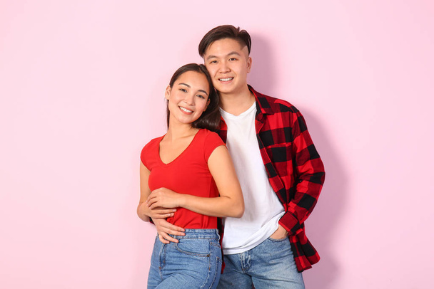 Portrait of happy young Asian couple on color background - Photo, Image