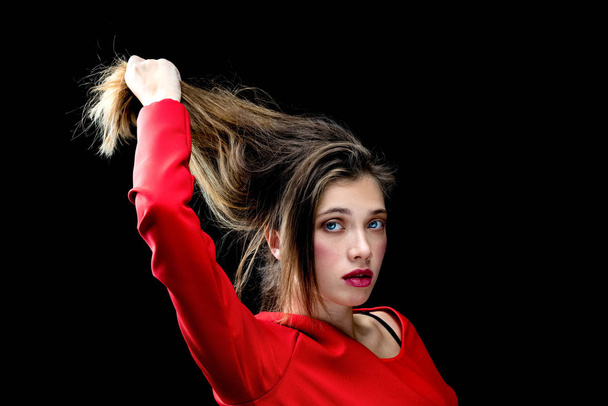 Gorgeous young woman in red dress posing against dark studio bac - Zdjęcie, obraz