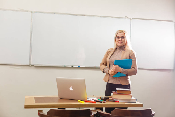Schöne Lehrerin im Klassenzimmer mit Laptop - Foto, Bild