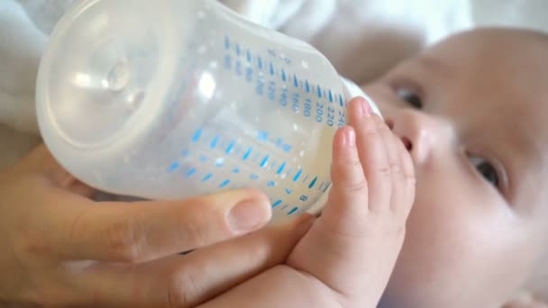 かわいい赤ちゃんの男の子は瓶に保持し、それから牛乳を飲みます, 4k - 映像、動画