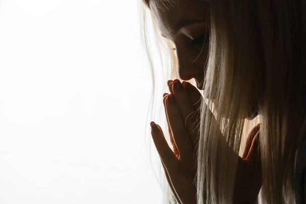 Hermosa pelirroja pecosa joven adolescente reza. Retrato de cerca de una mujer rezando
 - Foto, imagen