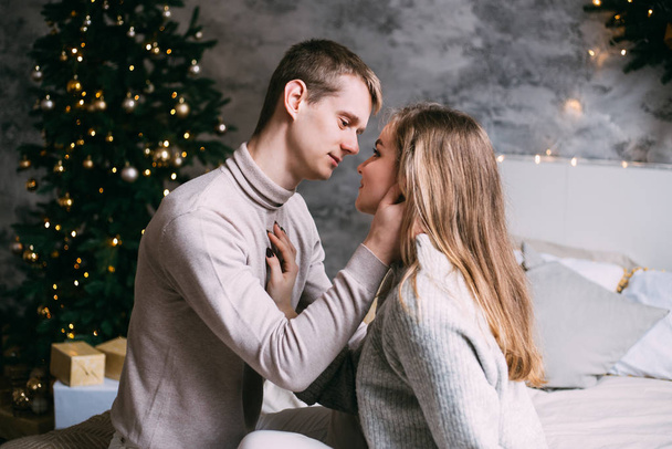 Young sweet pretty couple in love kissing on Christmas time - Foto, Bild