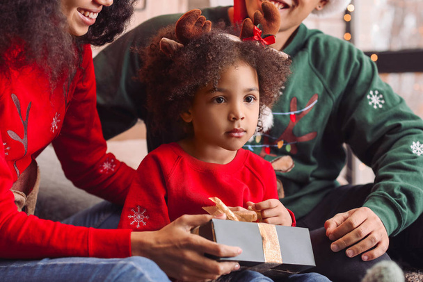 Gelukkig Afrikaans-Amerikaans gezin met cadeau thuis op kerstavond - Foto, afbeelding