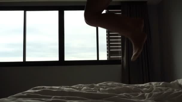 zpomalený film, sexy mladá žena tančí na posteli v temném pokoji - Záběry, video