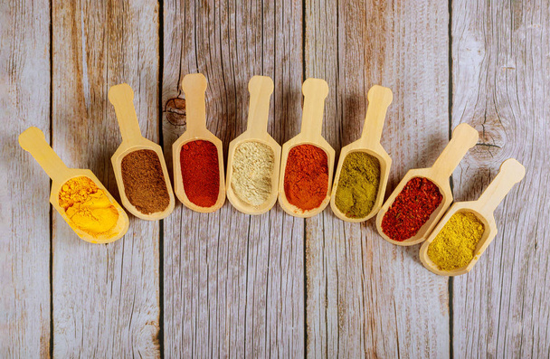 Eight wooden spoons of asian spices on wooden table. - Photo, Image