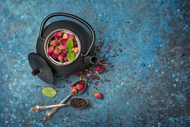 Black japanese cast iron teapot with rose tea and mint - Valokuva, kuva