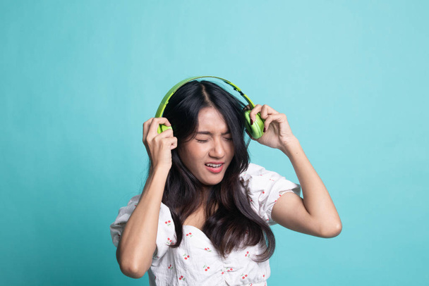 Too loud.  portrait of  young asian woman  holding  headphones a - Foto, Bild