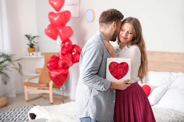 Happy young couple celebrating Valentine's Day at home - 写真・画像