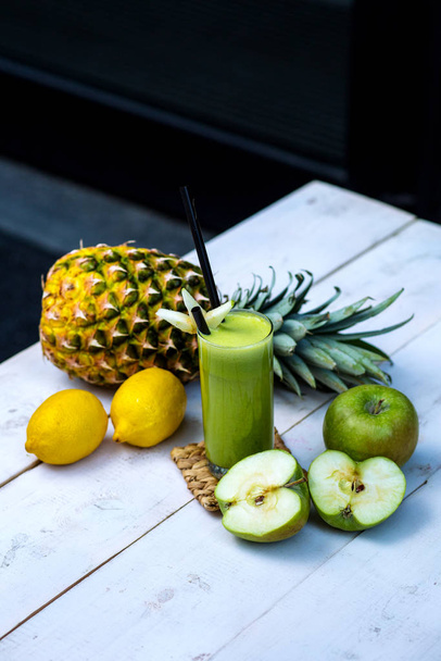 green apple juice served with apple, pineapple and lemons on - 写真・画像