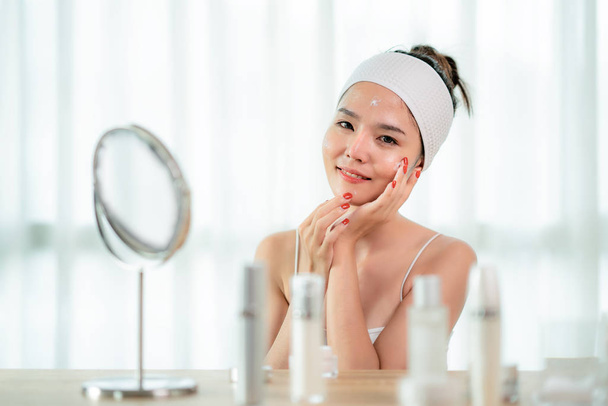 Porträt der schönen asiatischen jungen Frau, die sich um ihre Haut kümmert - Foto, Bild