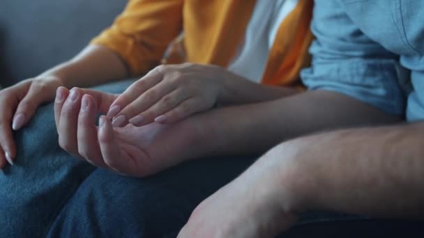 Κοντινό πλάνο των αρσενικών και θηλυκών χεριών που κρατούν ο ένας τον άλλο εκφράζοντας την αγάπη τους μετά από καυγά στο σπίτι - Πλάνα, βίντεο