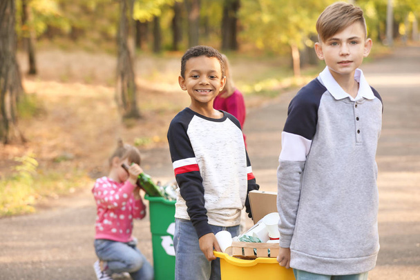 Kleine kinderen die vuilnis buiten verzamelen. Concept van recycling - Foto, afbeelding