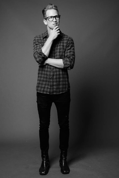 Studio shot of young handsome hipster man in black and white - Fotoğraf, Görsel