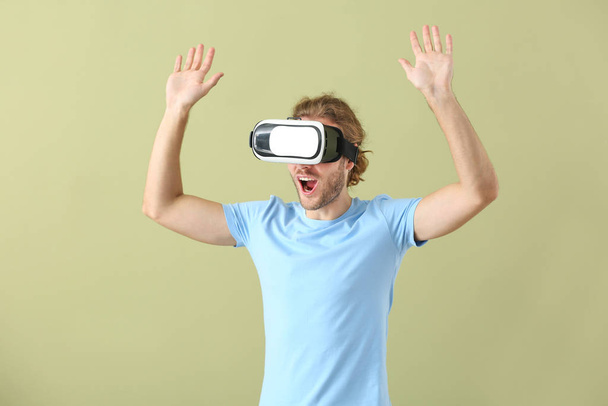 Joven con gafas VR sobre fondo de color - Foto, imagen