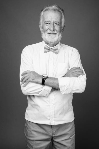 Όμορφος γενειοφόρος ηλικιωμένος άνδρας που φοράει κομψά ρούχα σε μαύρο και άσπρο - Φωτογραφία, εικόνα