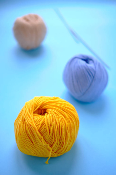helle Farbigkeit Garn Clews auf dem blauen Hintergrund. Konzept der amigurumi Spielzeugherstellung, Basteln, Stricken, Hobby - Foto, Bild