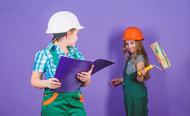 engineering idea. Future career. Labor day. 1 may. Little kids in helmet with tablet and roller. Foreman inspector. Repair. small girls repairing together in workshop. I need help. can you help me - Fotoğraf, Görsel