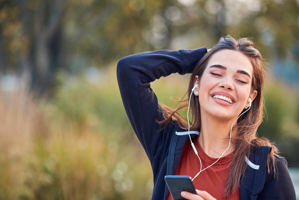 Modern young woman with cellphone making pause during jogging /  - Photo, image