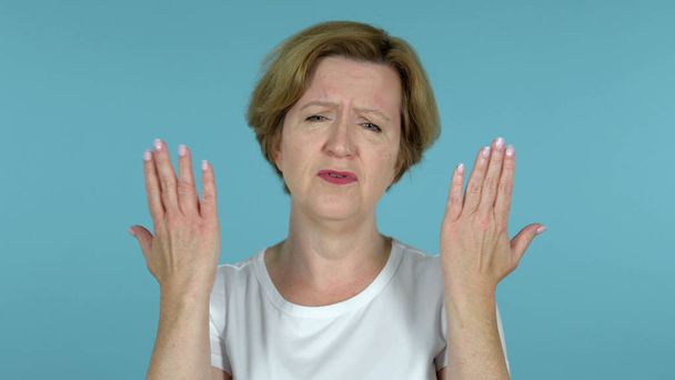 alte Frau gestikuliert Versagen und Probleme isoliert auf blauem Hintergrund - Foto, Bild