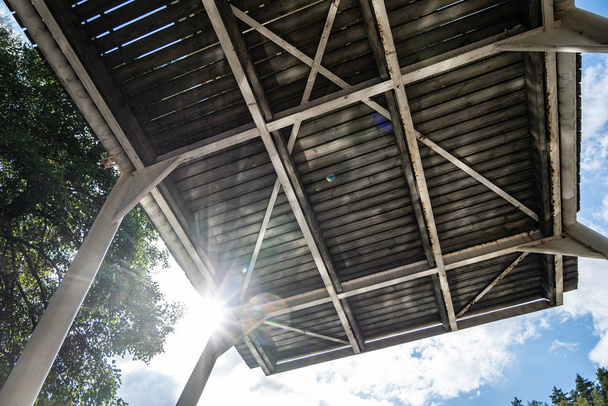Hochsprungbrett für trainierende Sportler, vor dem Hintergrund der strahlenden Sonne, des blauen Himmels und der Bäume, im Freien.  - Foto, Bild